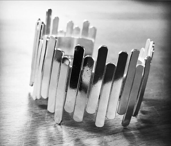 A handmade silver bracelet shaped as sticks put together randomly