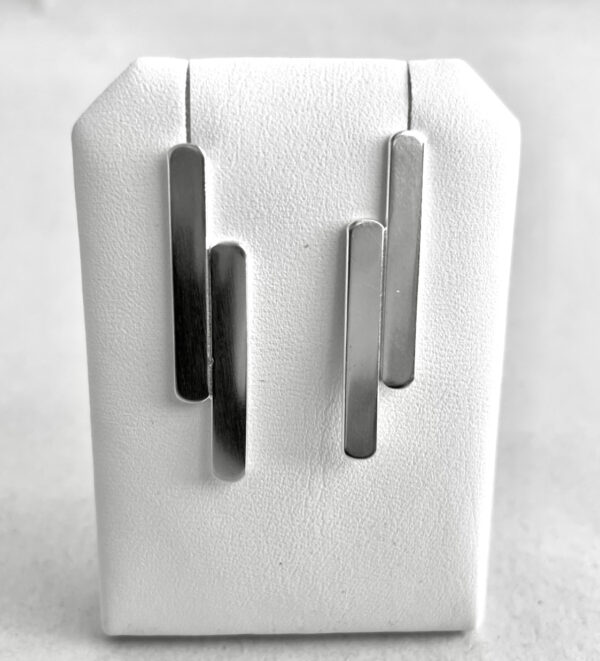 Two handmade silver earrings shaped as two flat sticks unsymetrically attached to each other.