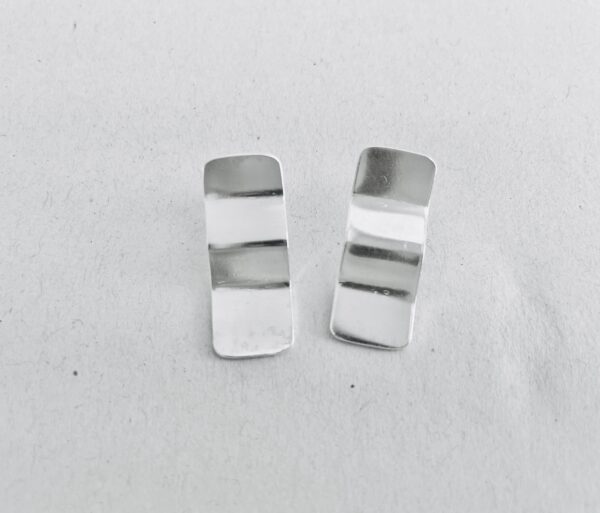 A pair of silver earrings shaped as wavy rectangles